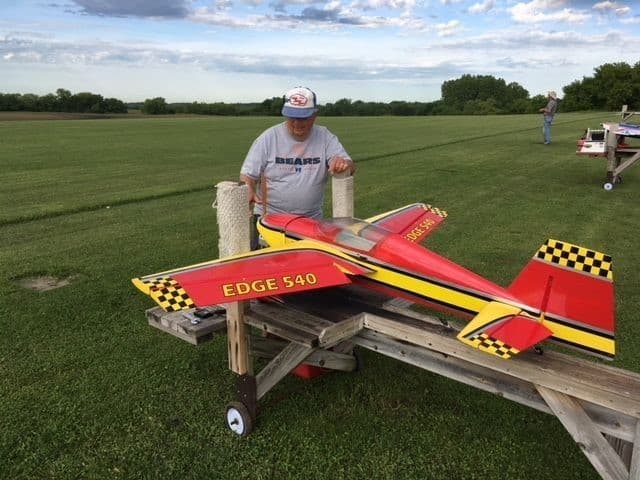 Red model airplane flying over Poplar Creek